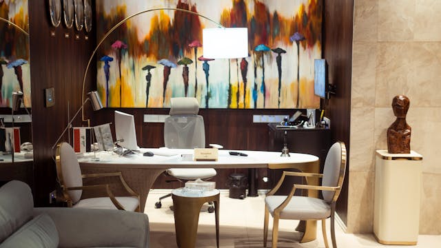 Oficina moderna y elegante con mobiliario de diseño, arte abstracto en la pared y ambiente profesional, ideal para asesorías, gestorías o despachos inmobiliarios.